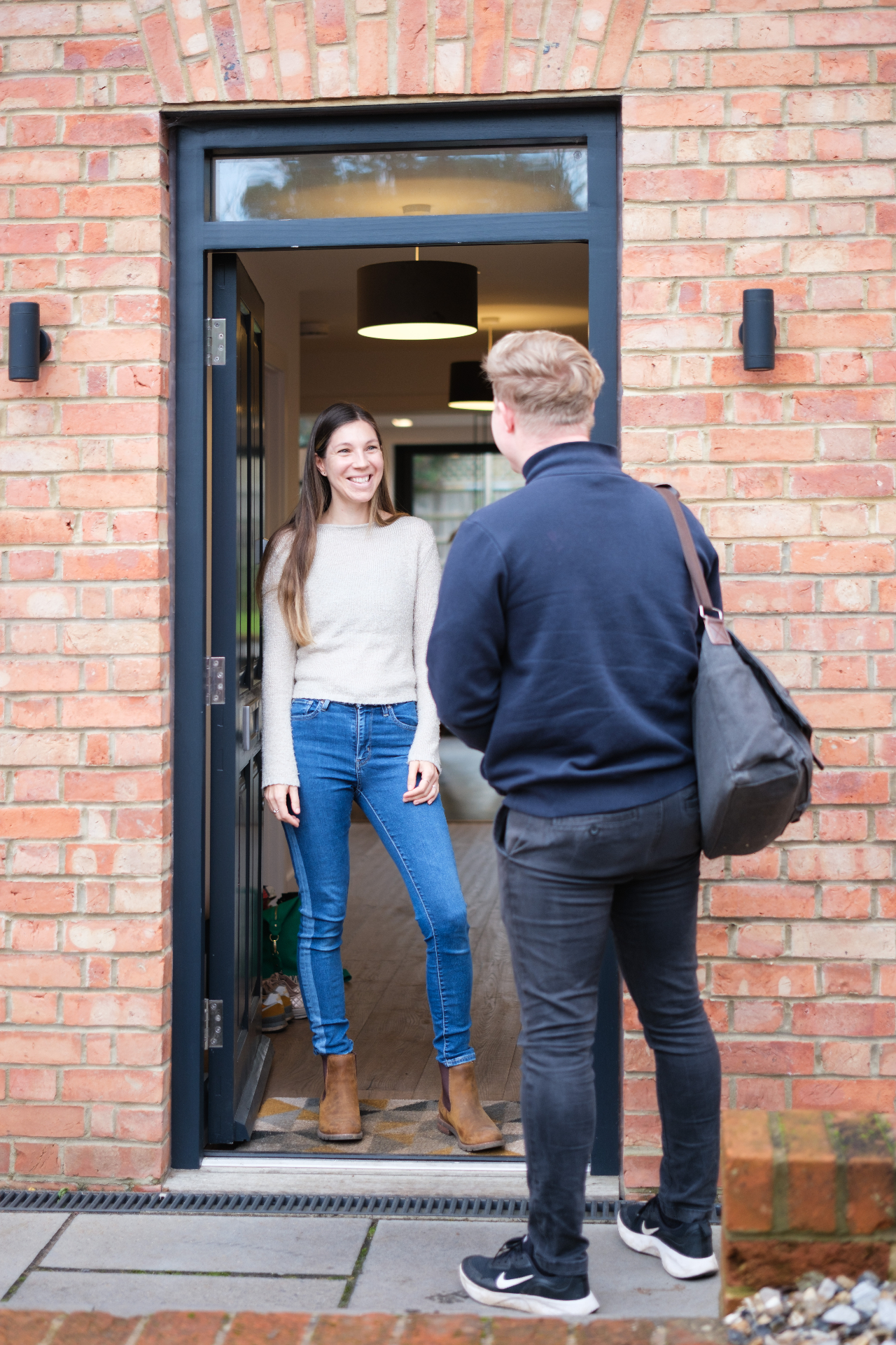 Premier Heating engineer greeted at the front door by a happy homeowner after completing the boiler replacement.