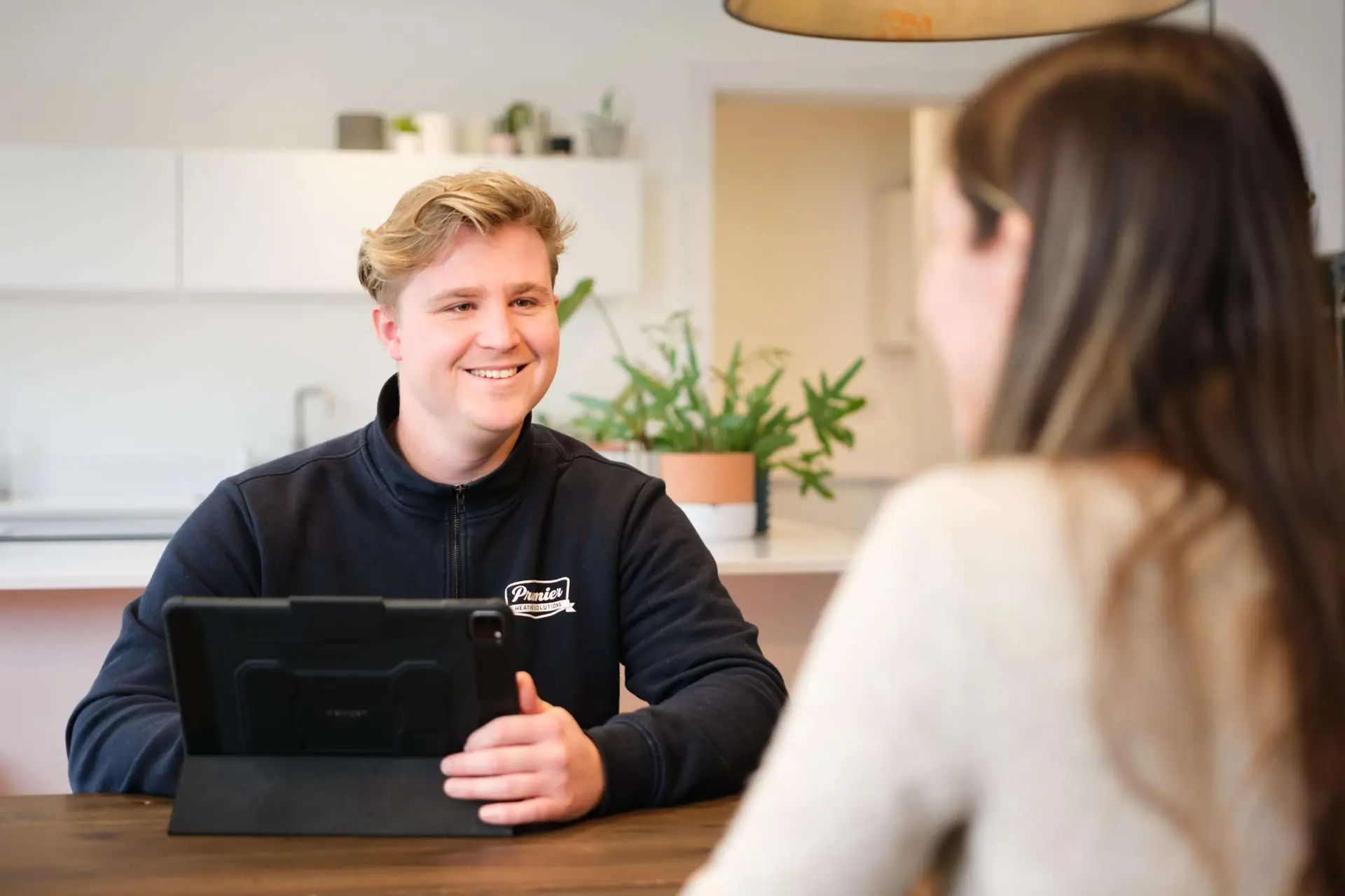 Premier Heating Solutions engineer talking with a homeowner